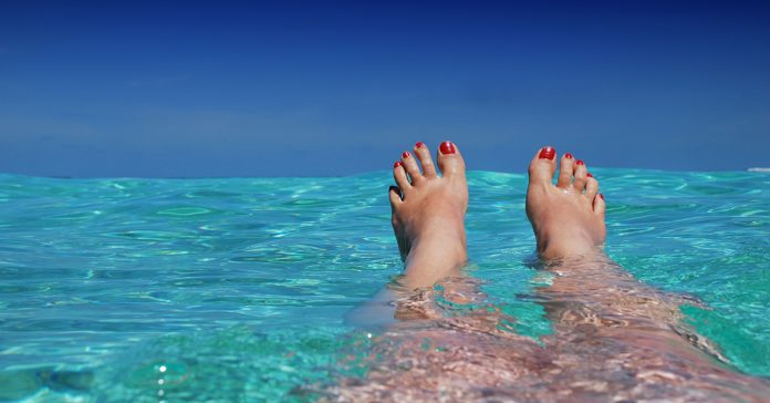 pekne nohy na plazi vo vode mora